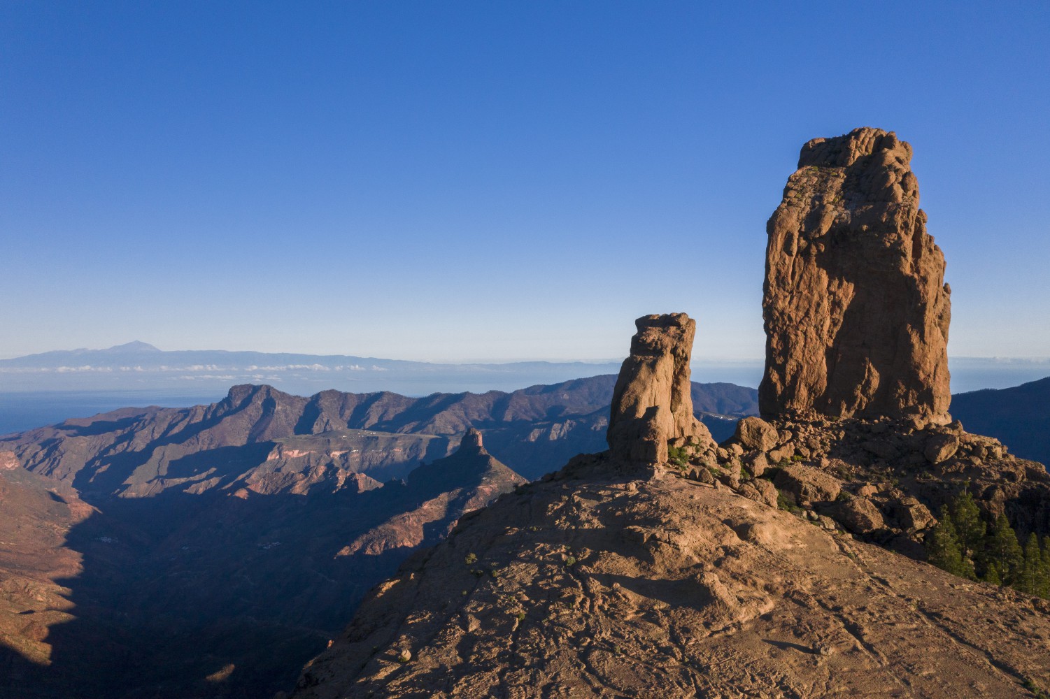 Felsnadeln auf einem Höhenrücken mit Blick über eine zerklüftete Berglandschaft bis zum Atlantik.